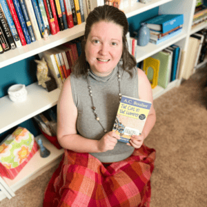 Accessible image showing a team member holding a children's book in a library.