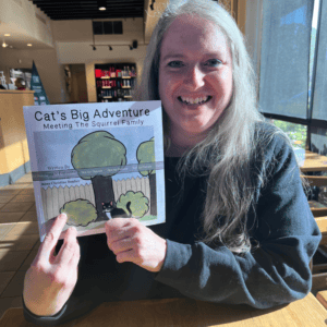 Accessible team member holding a children's book about squirrels.