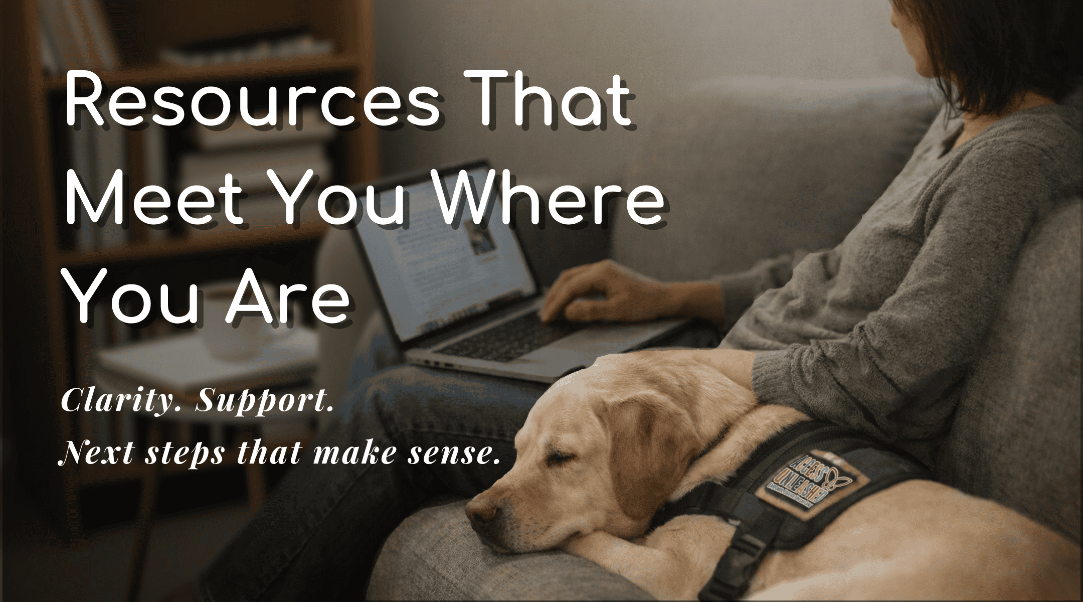 Person using a laptop with a service dog, promoting accessible resources.
